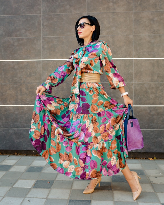 Businesswoman in elegant colorful silk dress and purplish handbag