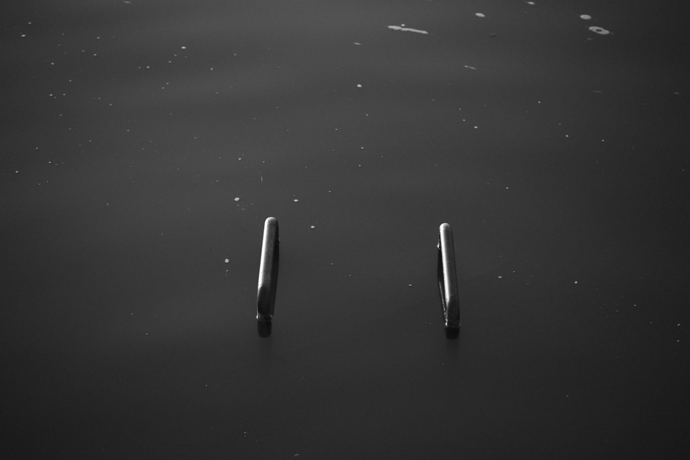 Foto in bianco e nero di tubi metallici allagati in acqua