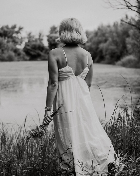 Fotografía monocromática de mujer en vestido blanco afuera