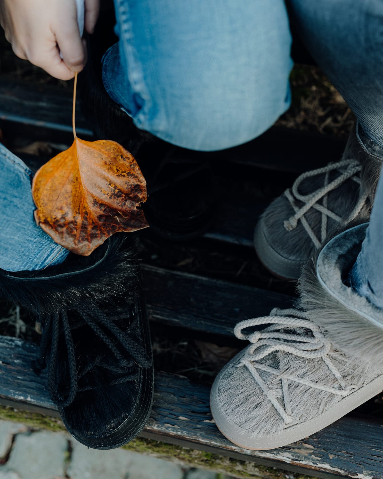 Gros plan sur les bottes de la saison d’automne et la feuille jaunâtre