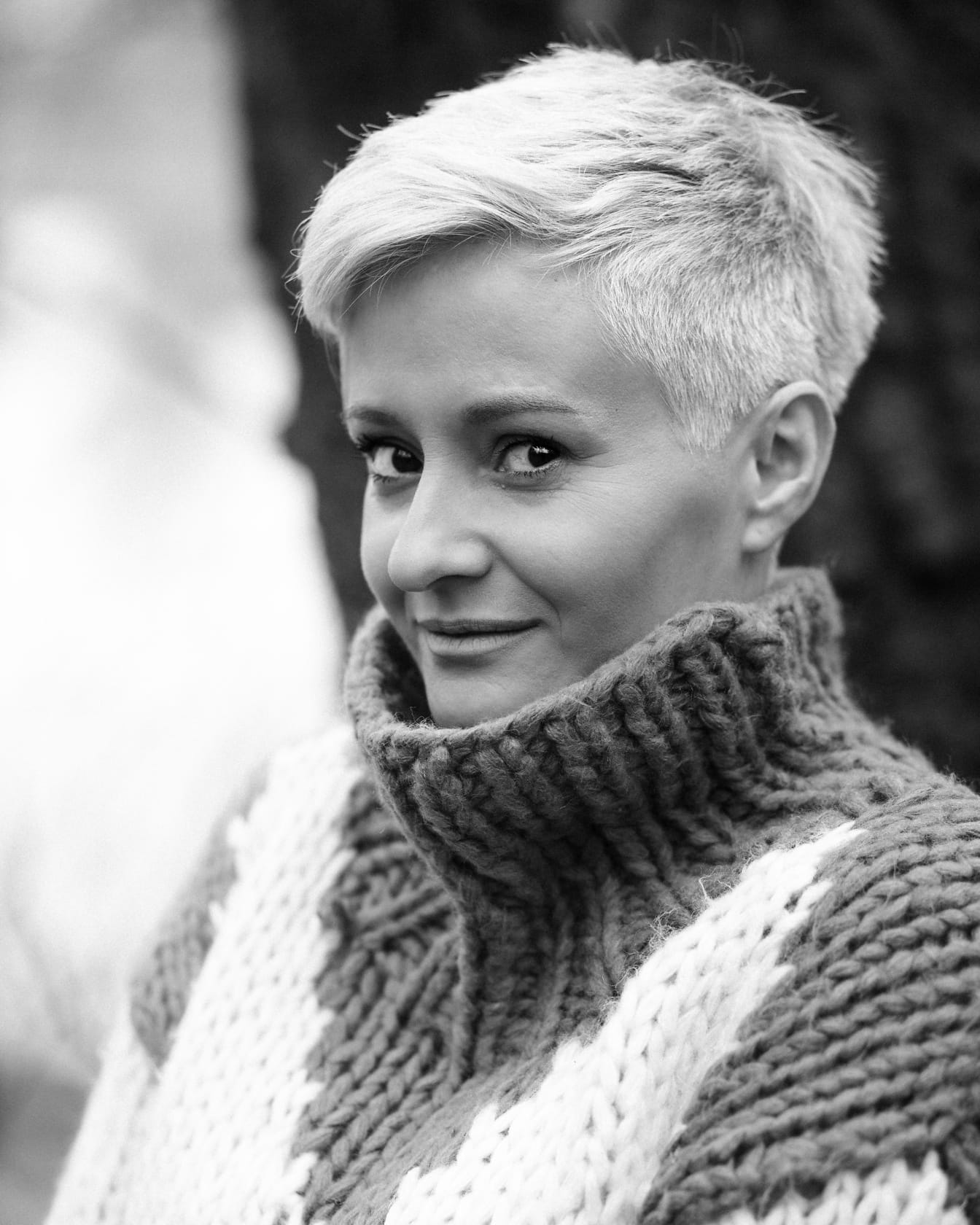 Portrait monochrome d’une jeune femme blonde en pull en laine