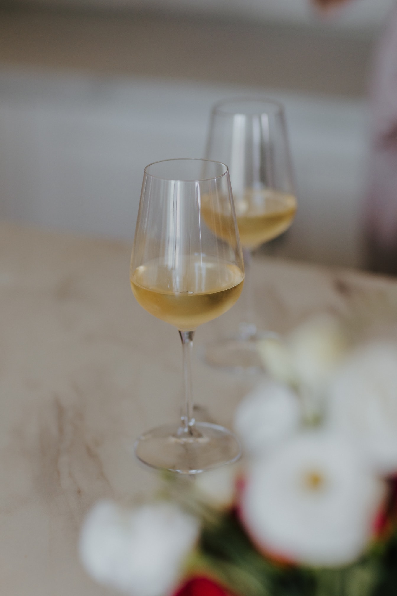 Elegantní křišťálové sklenice s bílým vínem na stole