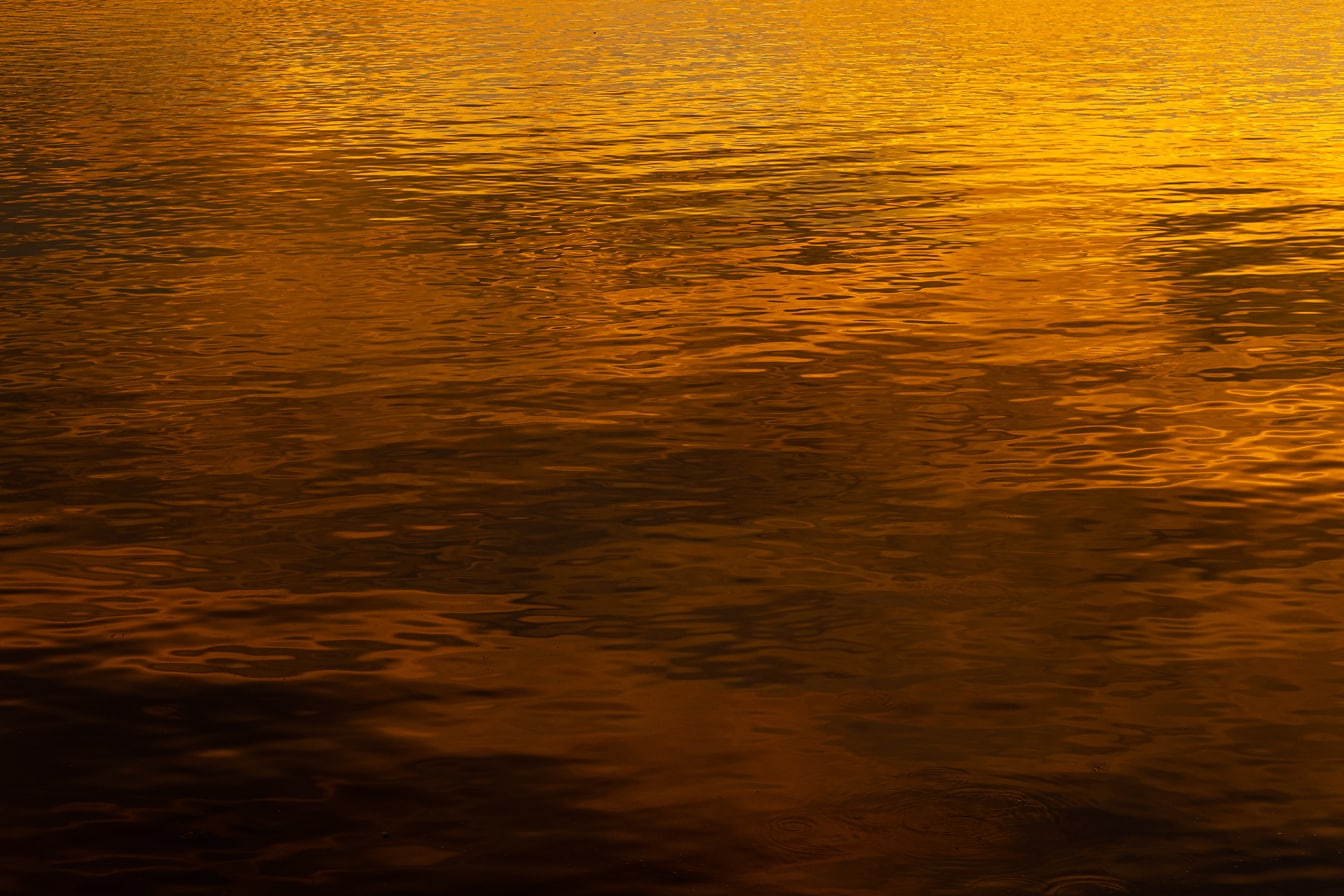 鲜艳的橙黄色日落反射在水面上