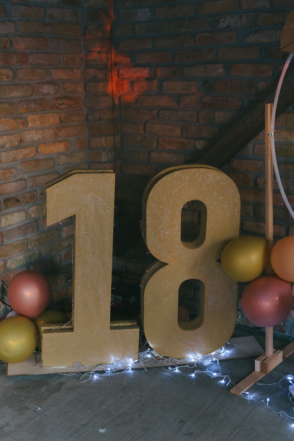 Goldene Glanzdekoration mit 18er Nummer auf Geburtstagsfeier