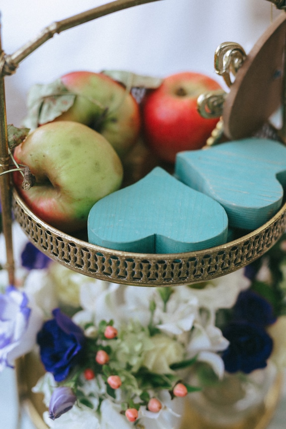 Handmade hearts in brass basket with apples close-up
