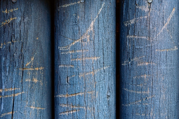 Mørkeblå maling på udskårne runde planker close-up tekstur