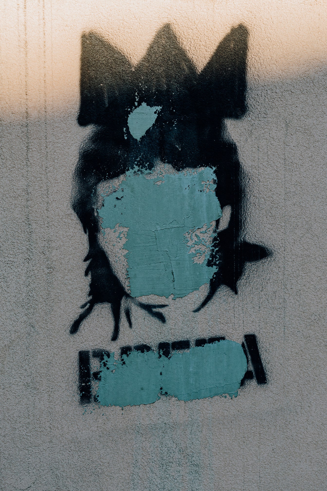 顔の上に描かれた黒い頭の落書き、都市の破壊行為