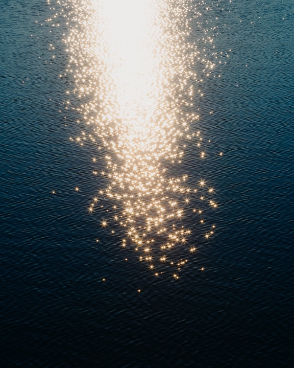 金色的光芒在平静的水面上反射阳光