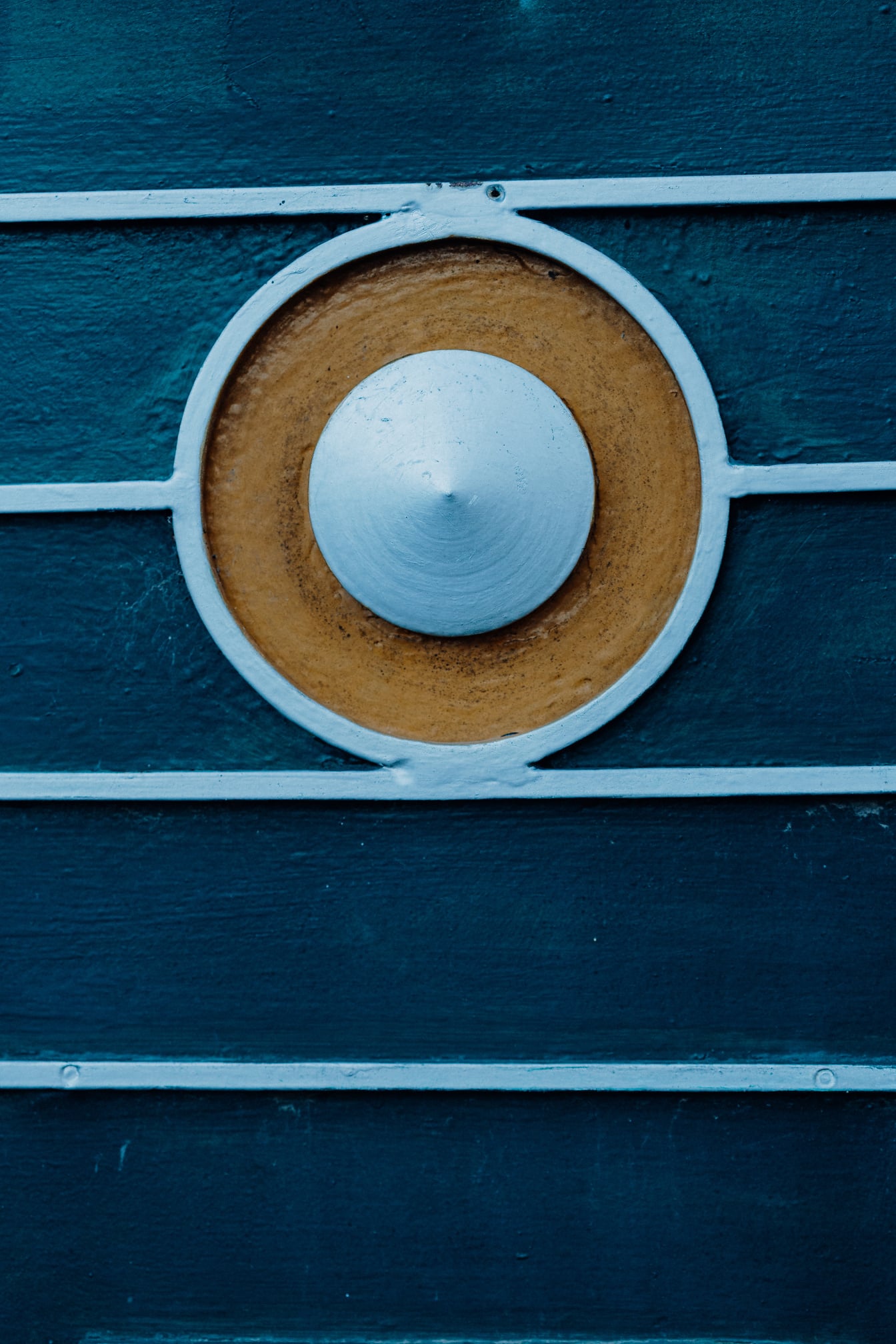Kovová dekorace kulatého tvaru na tmavě modrém lakovaném kovu