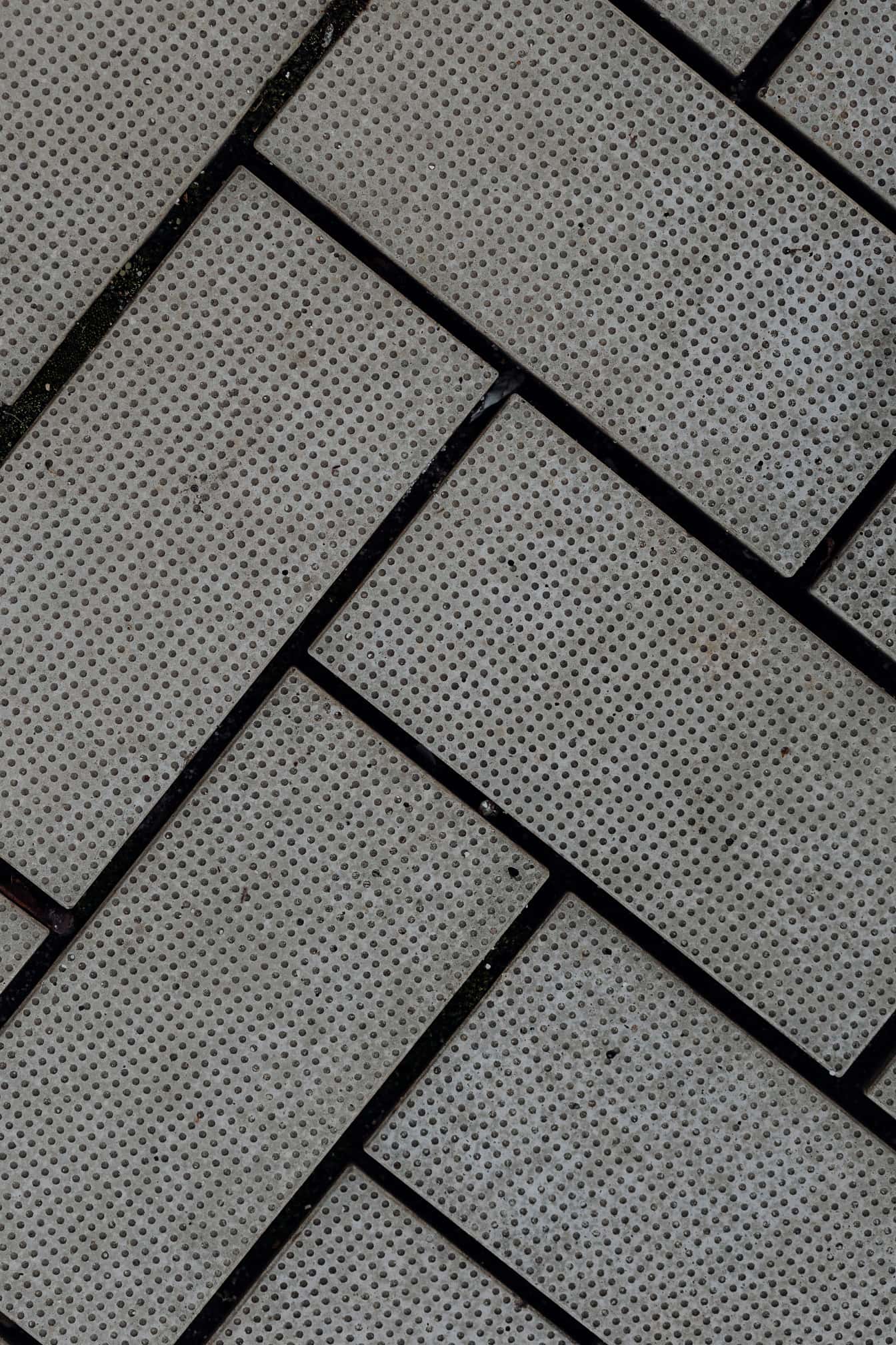 Tijolos de concreto com padrão de espinha de arenque e argamassa preta