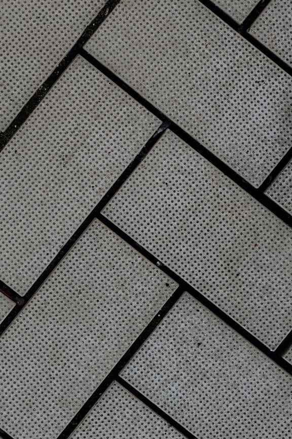 Betonové cihly se vzorem rybí kosti a černou maltou