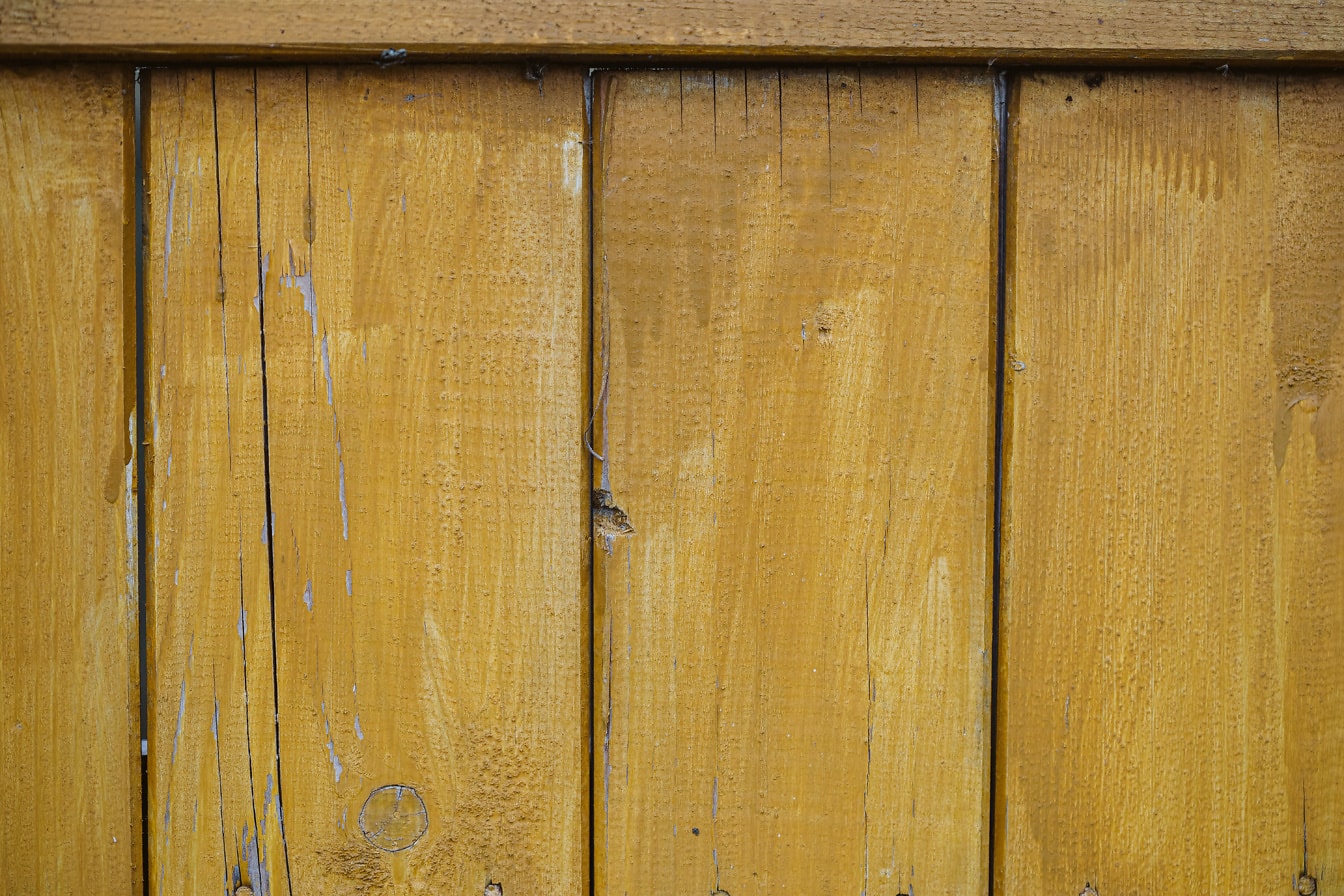 Жълтеникавокафява боя върху вертикални дървени планове близък план текстура