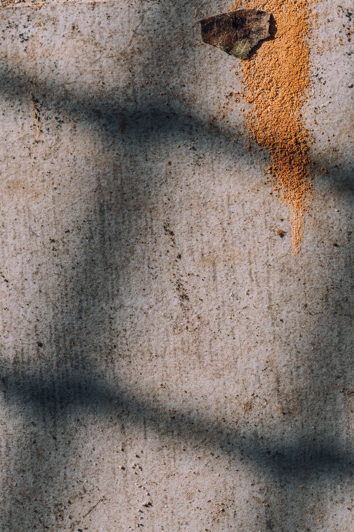 Vernice giallo arancione su texture ravvicinata del muro di cemento sporco