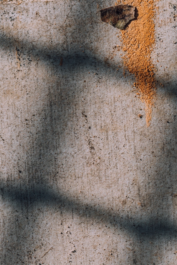 Orange yellow paint on dirty cement wall close-up texture