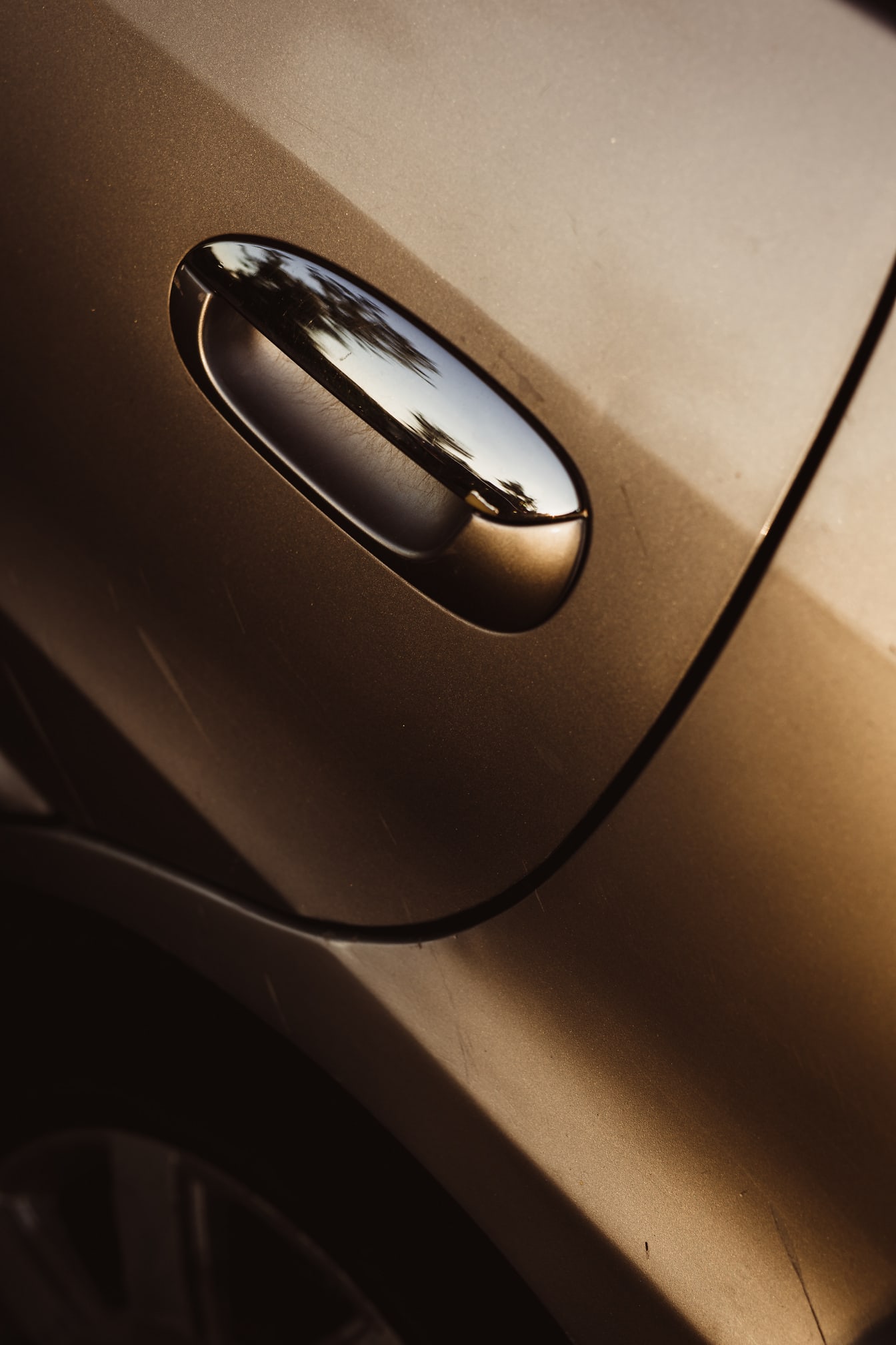 Guld- glöd metallisk färg och dörrhandtag av bilen