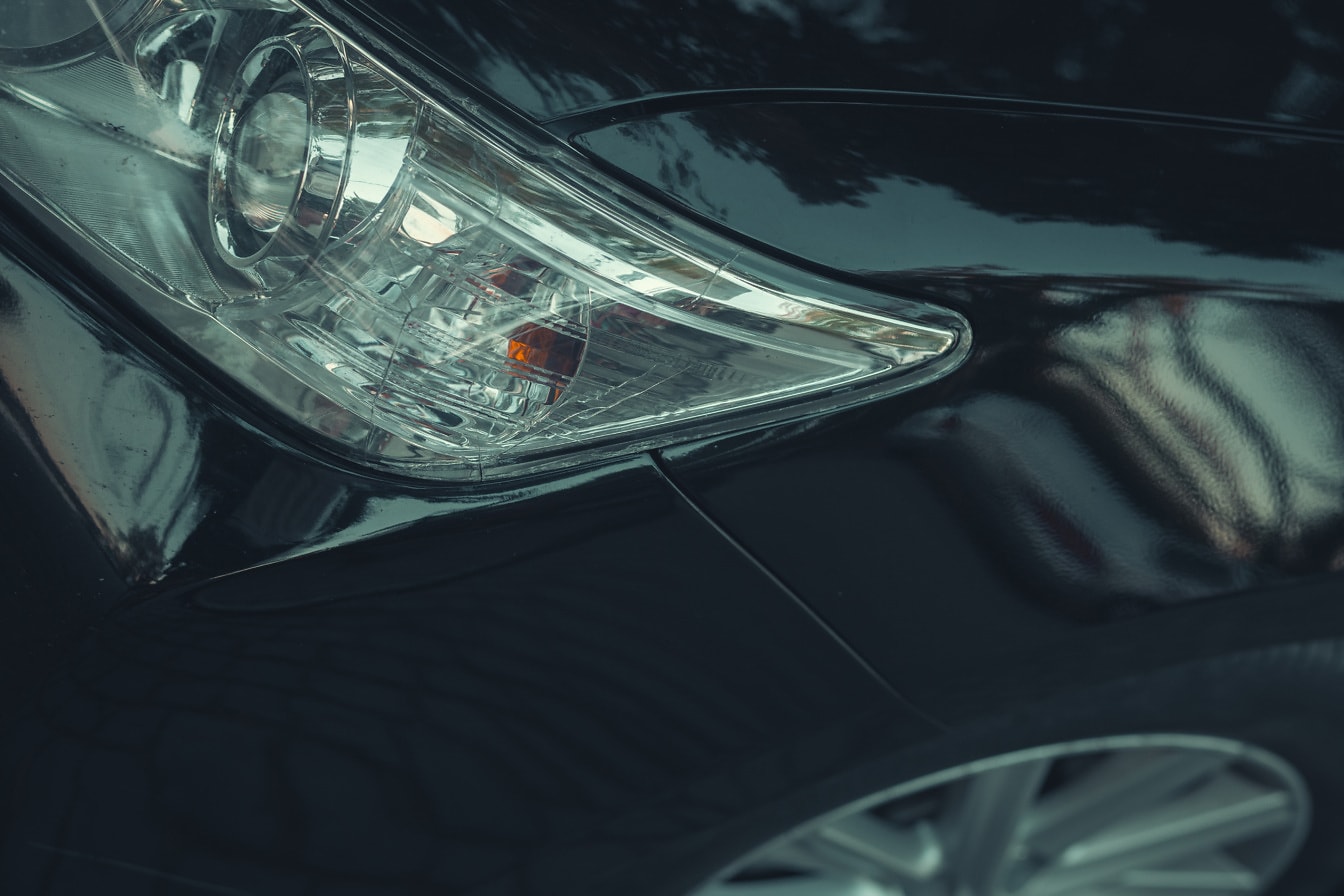 Close-up van koplampen op zwarte metalen auto