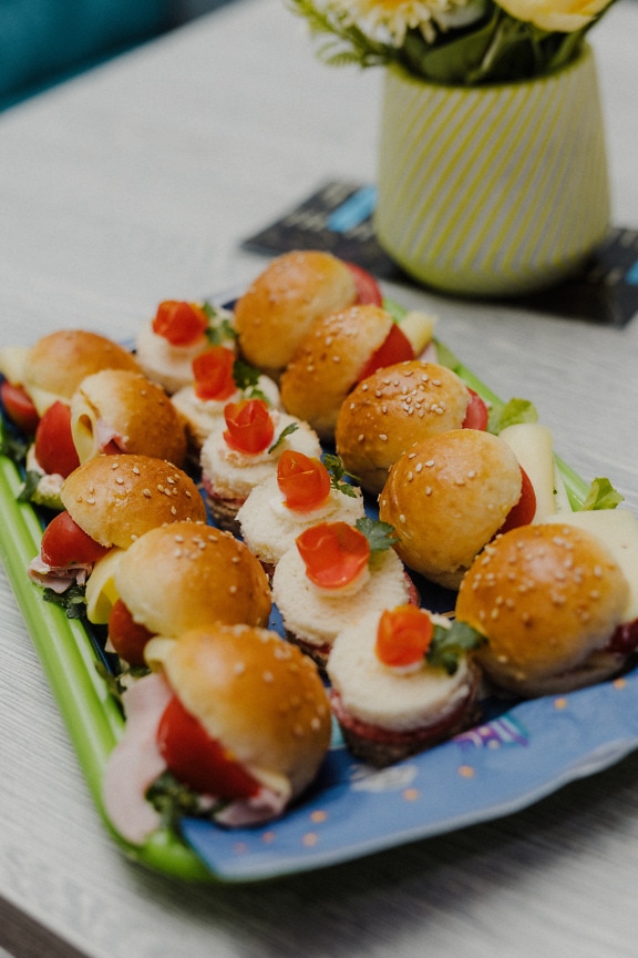 Miniature burgers and sandwiches appetizer on table