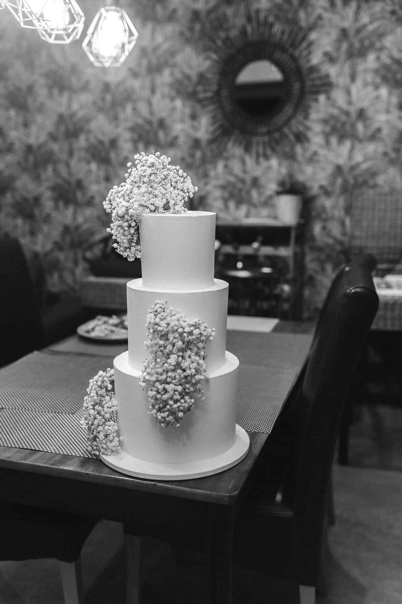 Monochrome photo of elegant wedding cake on restaurant table
