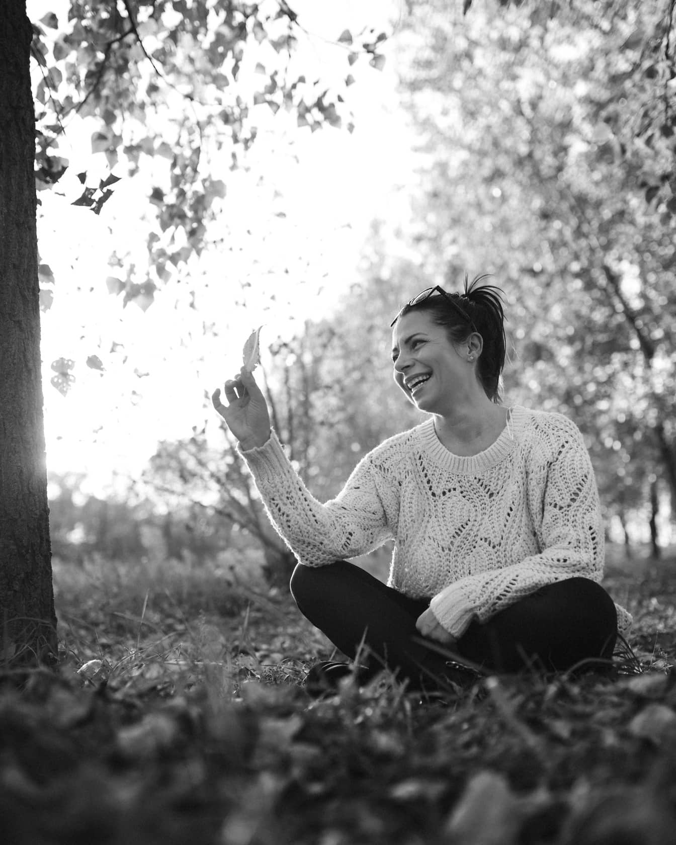 Mujer feliz sentada al aire libre y retrato monocromo sonriente
