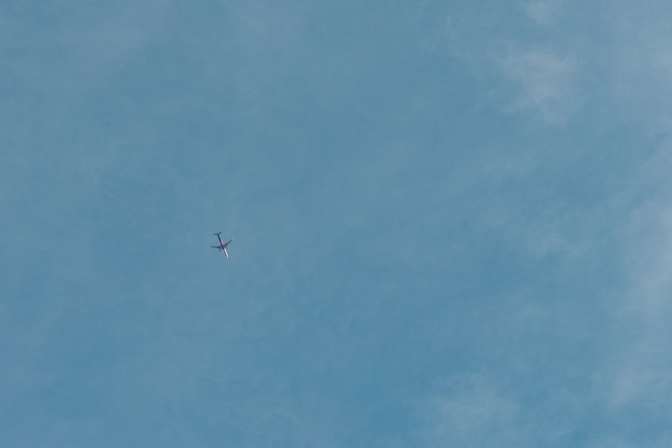 Синьо небе със самолет, летящ на разстояние