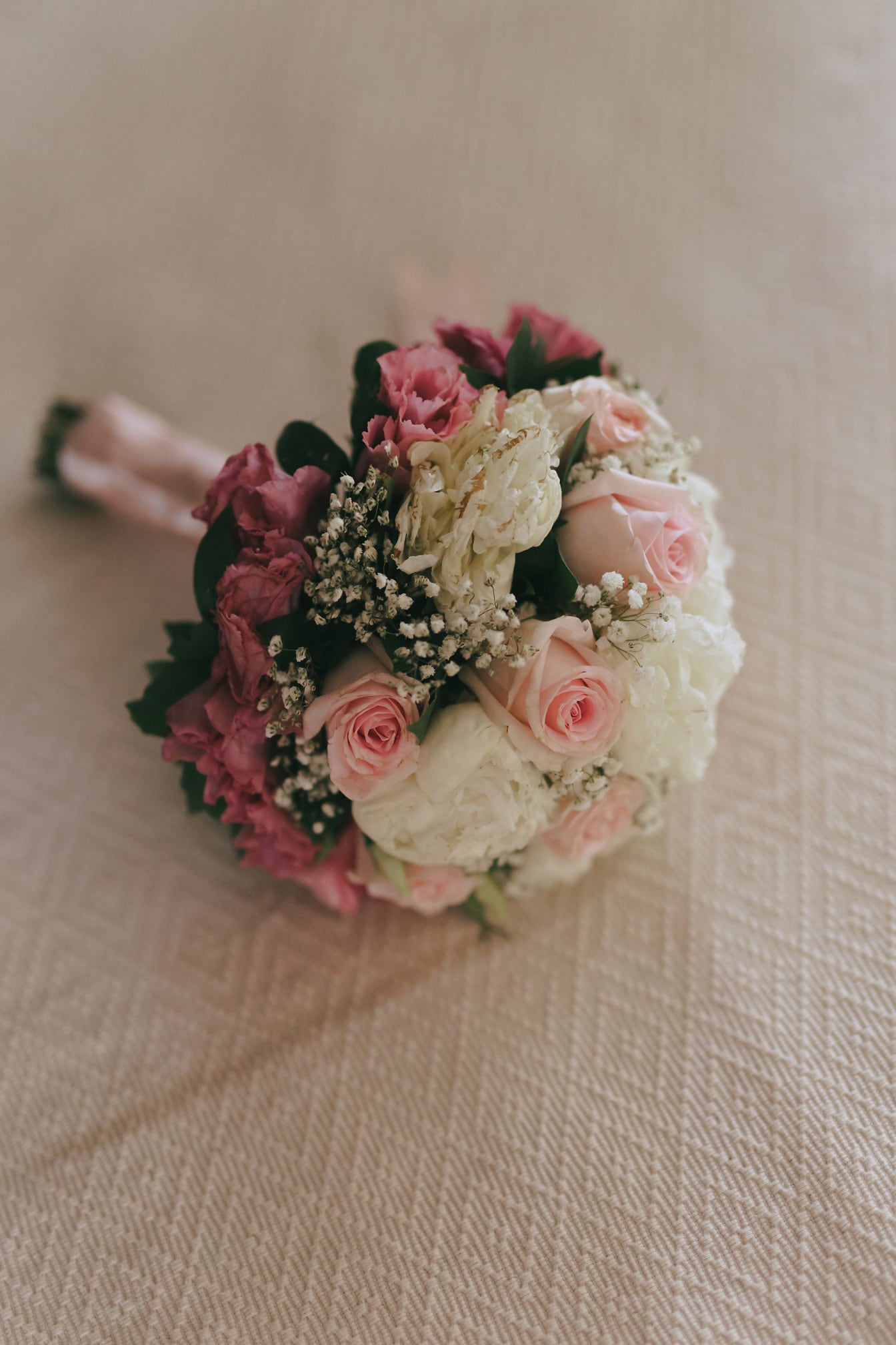 ช่อดอกไม้แต่งงานด้วยดอกกุหลาบสีชมพูและสีขาวพาสเทล