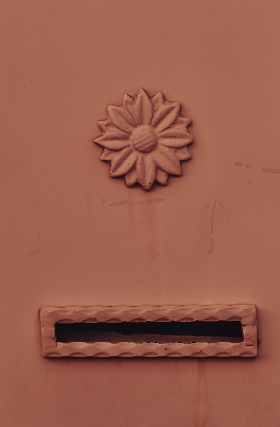 Old metal mail slot of mailbox with ornamental decoration