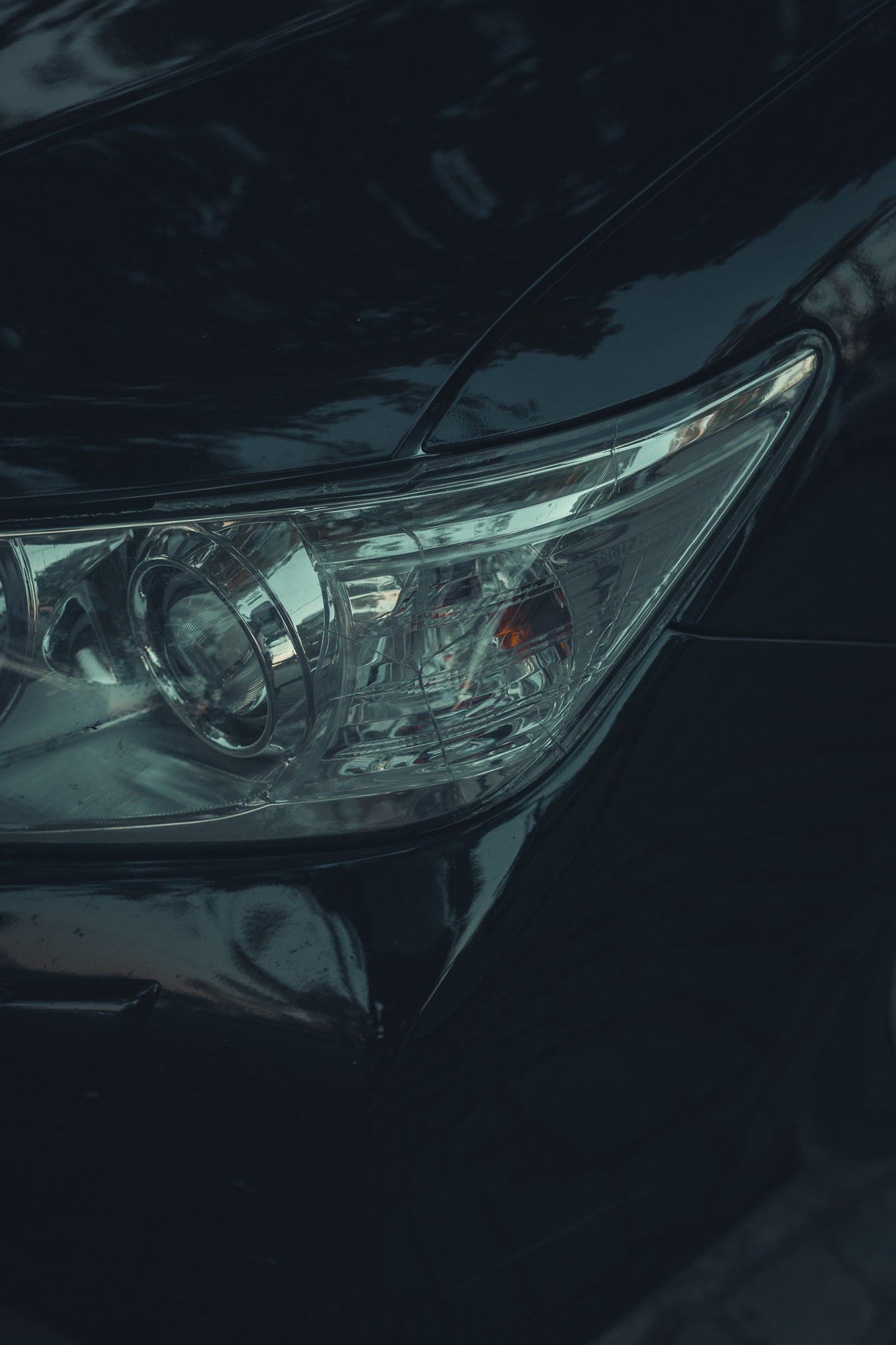 Detailný záber svetlometov na čiernom metalickom automobile