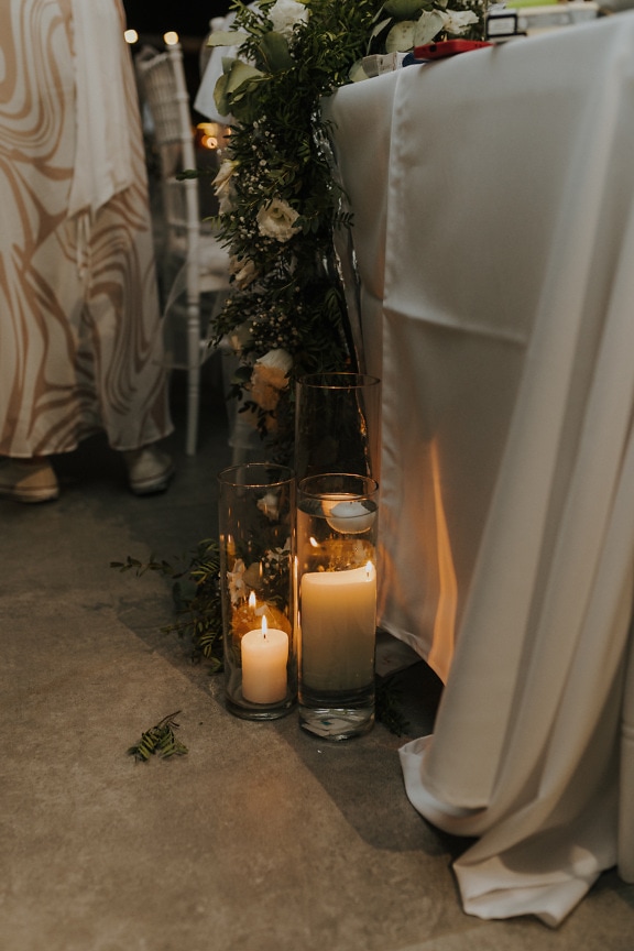 Elegante weiße Kerzen in Glasvasen am Hochzeitsort