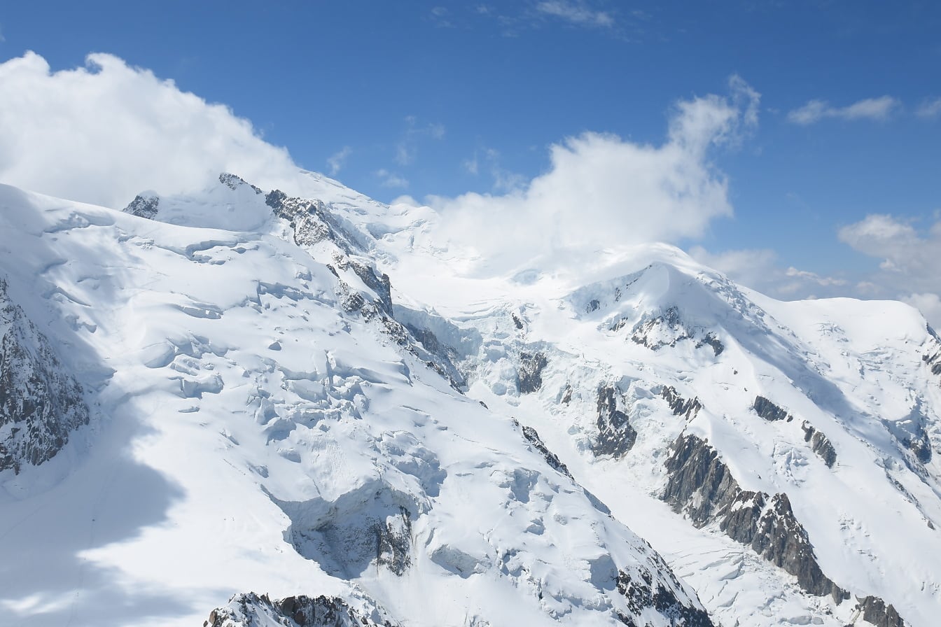 Алпите в Шамони със заснежени планински върхове и облаци на синьо небе
