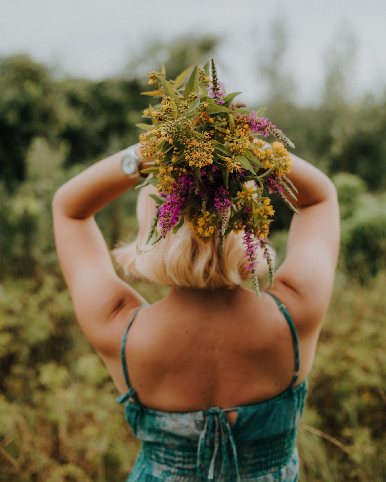 Kytica poľných kvetov v rukách blond ženy
