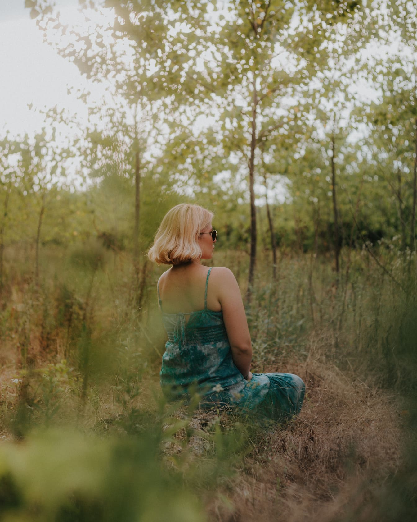 Fiatal nő ül és meditál az erdőben