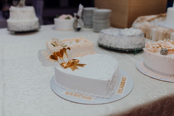 White creamy wedding cake with golden shine hears decoration