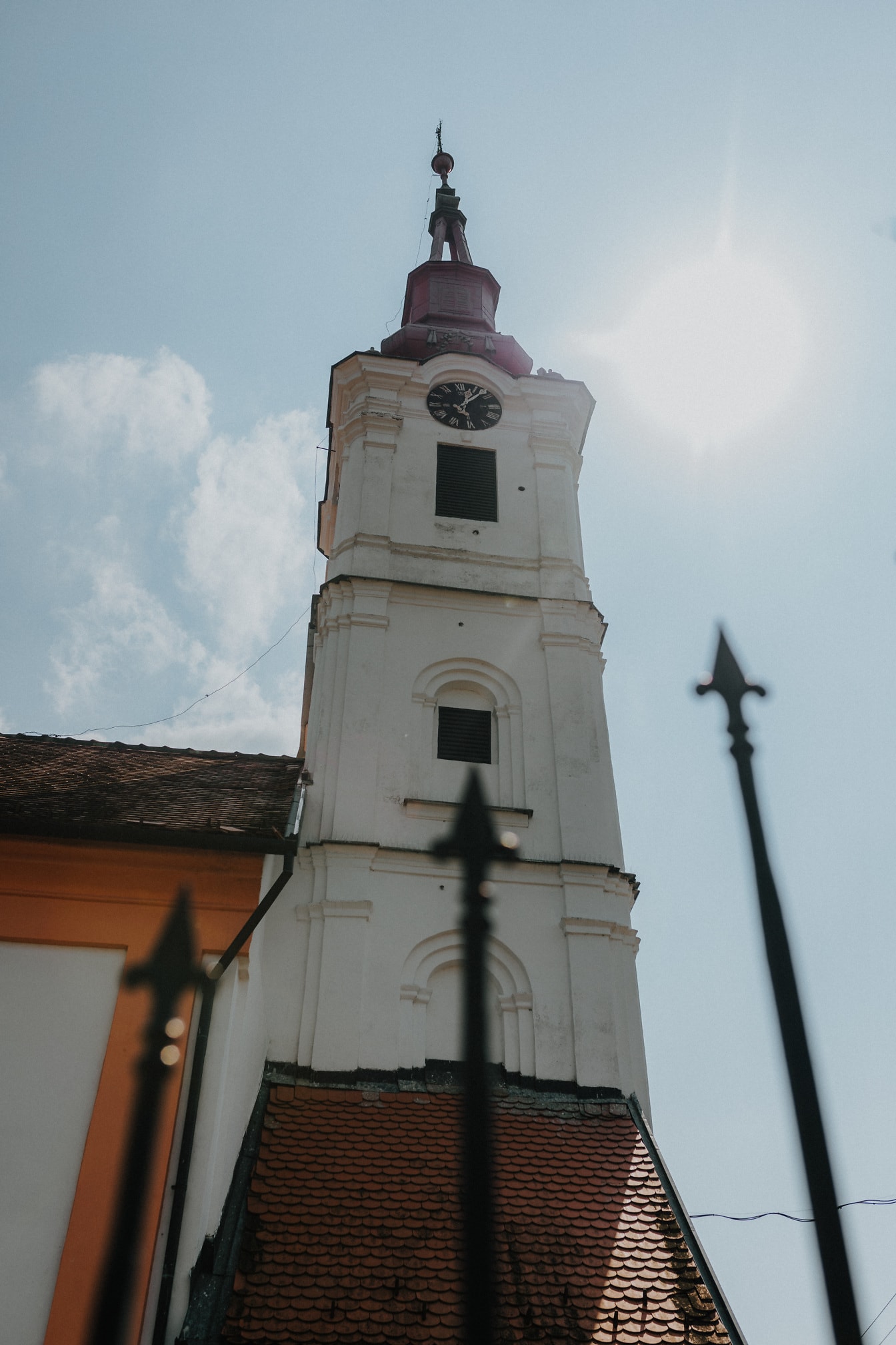 Campanile ortodosso bianco della chiesa con la luce del sole sullo sfondo