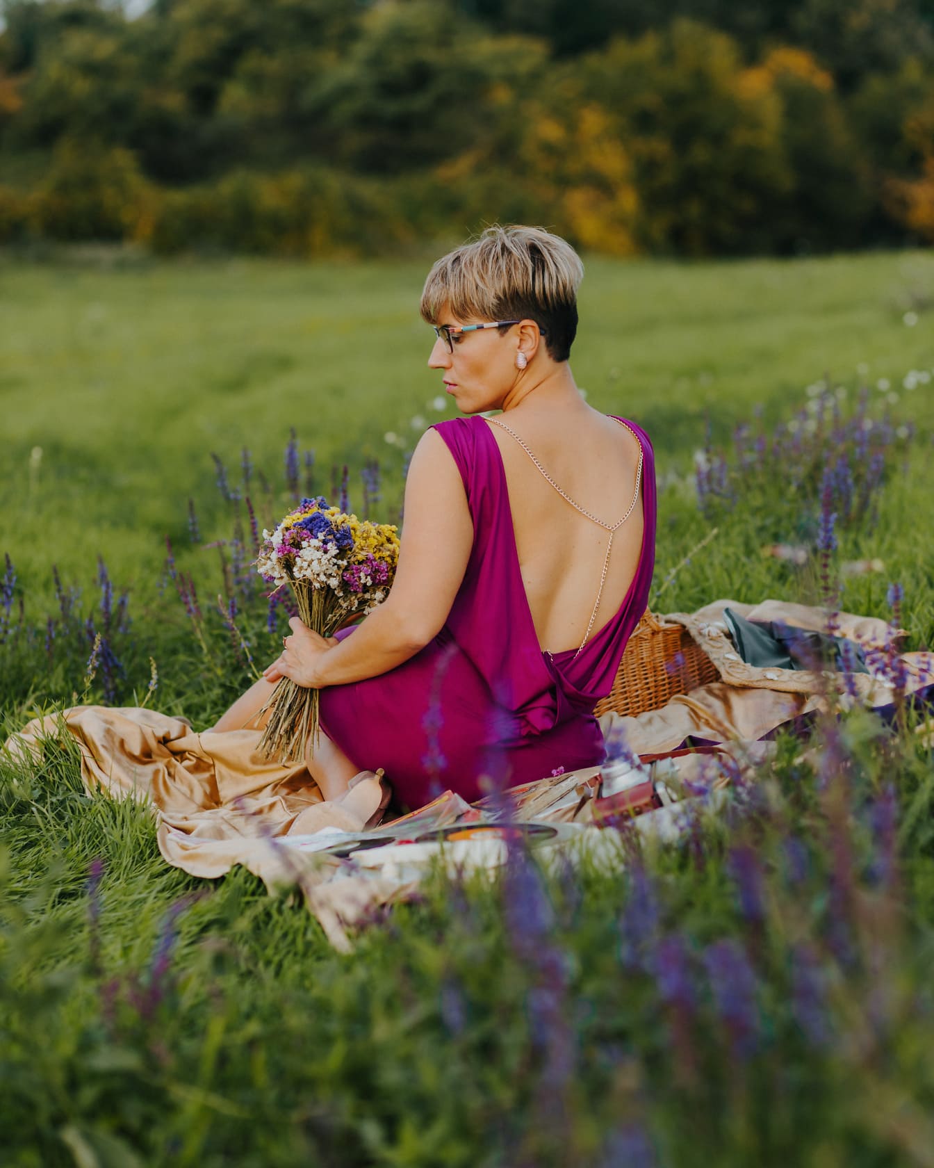 Атрактивна розова дама с букет цветя в одеяло за пикник