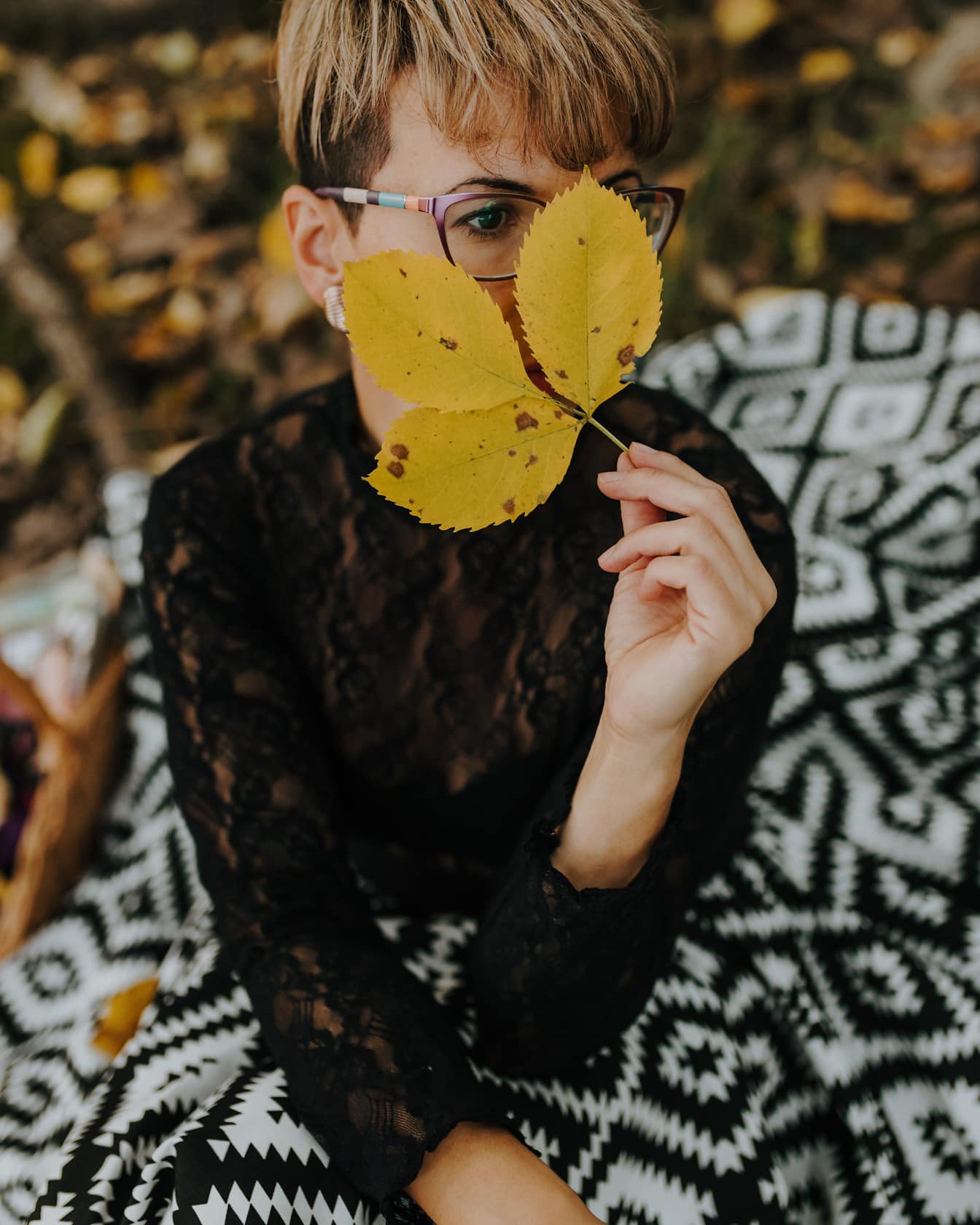 Atractiva mujer joven de cabello rubio con hojas en la cara