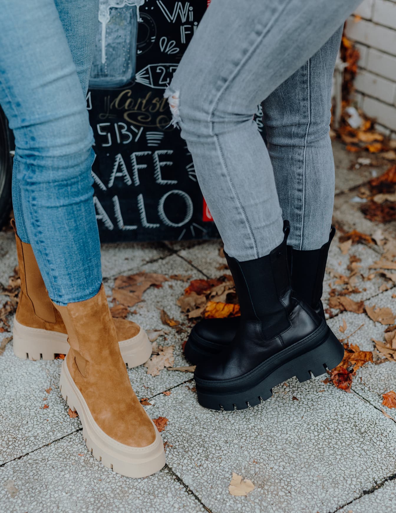 Gulbruna och svarta läderstövlar och jeansbyxor i denim
