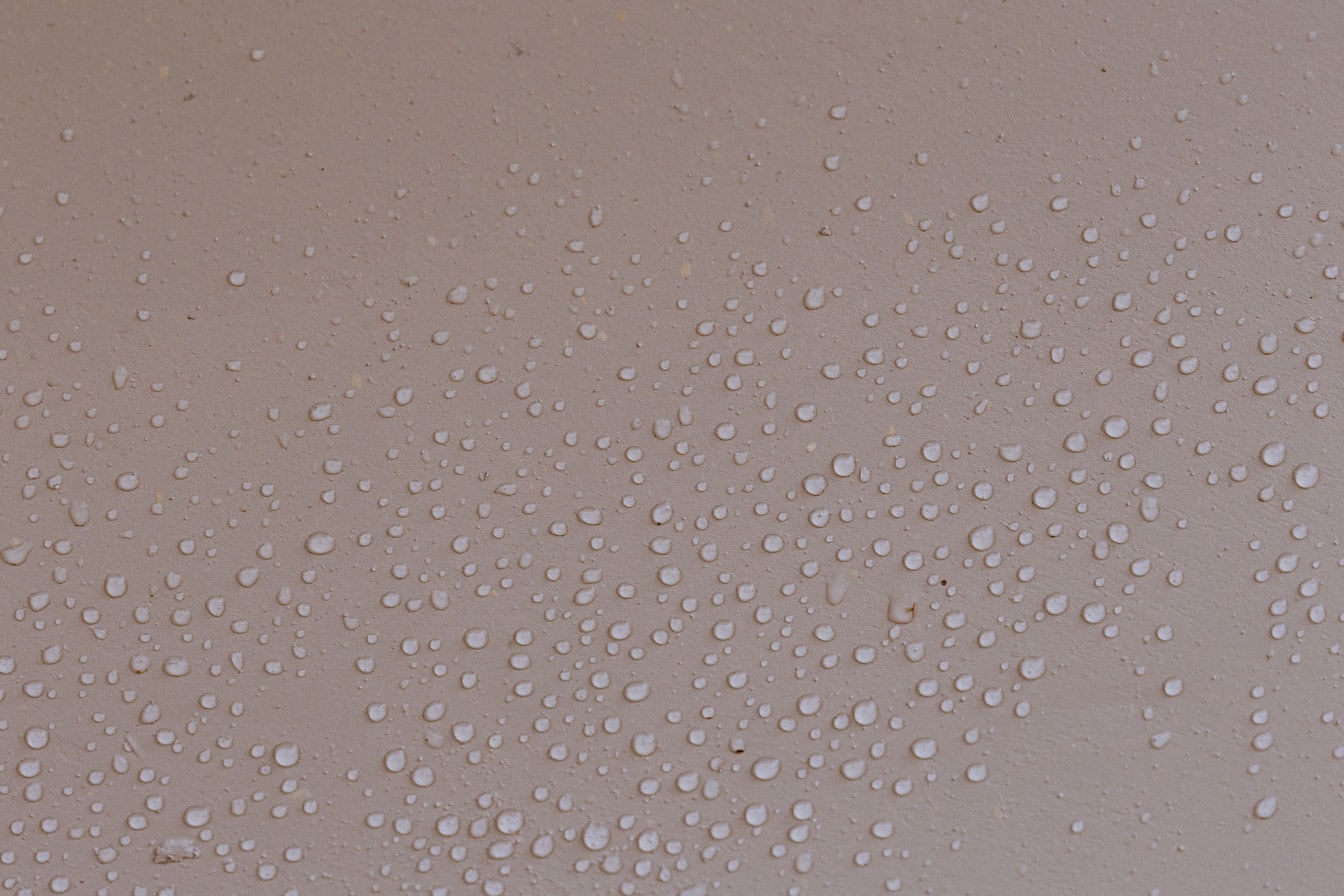 Condensación de humedad en la textura de primer plano de la pintura rosada