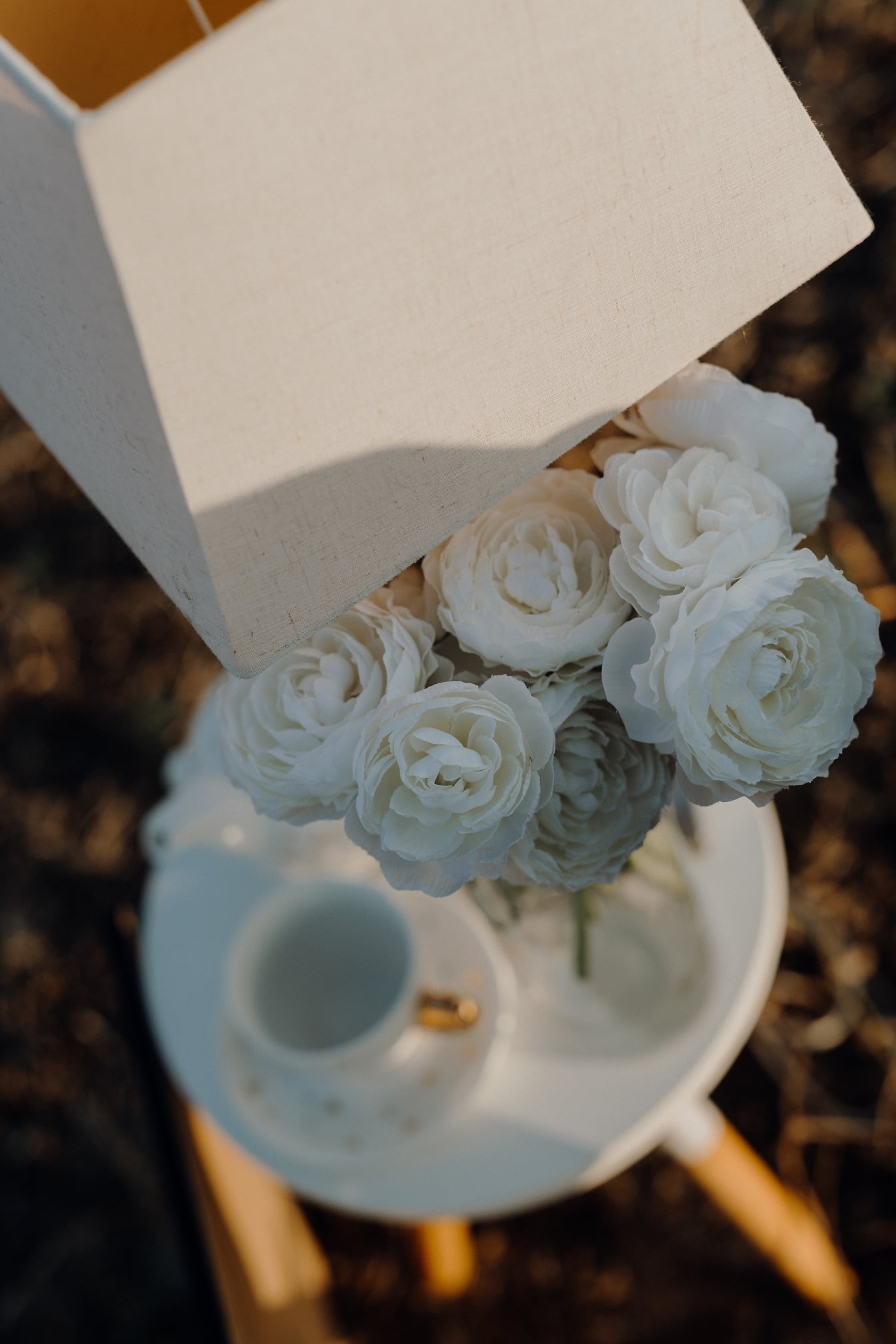 Buket mawar putih di bangku dengan dekorasi lampu elegan