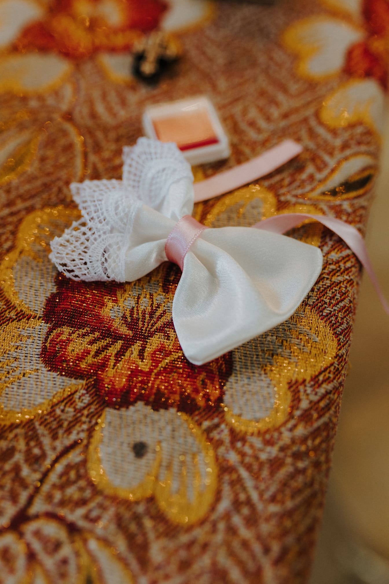 Nærbillede af hvid dekorativ taske med lyserødt bånd