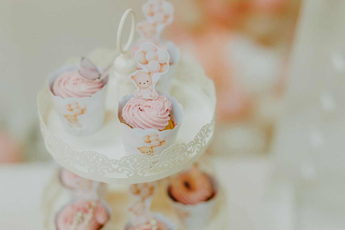 Cupcake vaaleanpunaisella kermalla ja hienolla koristeella lähikuva