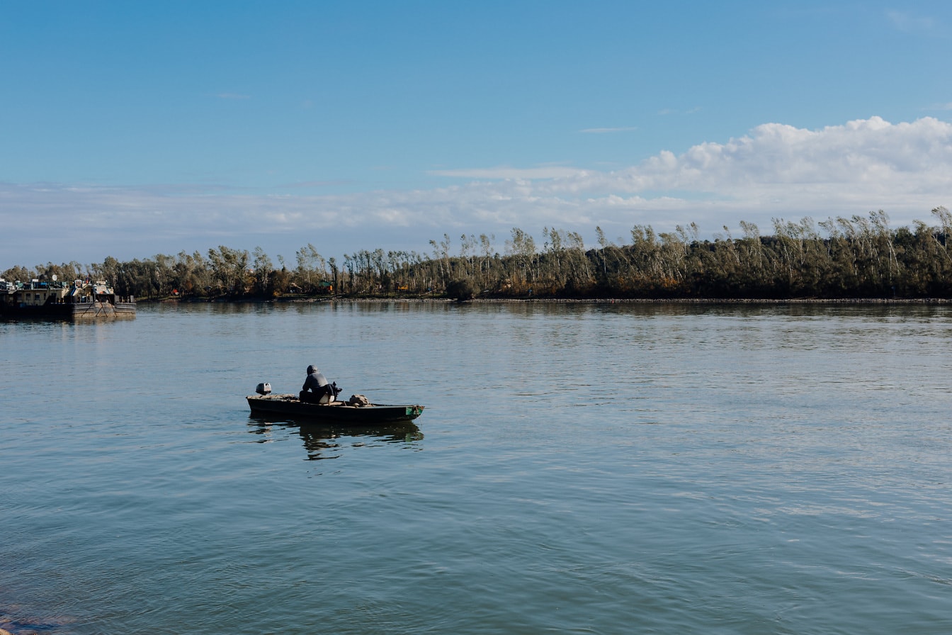 Pescador em pequeno barco de pesca no rio Danúbio