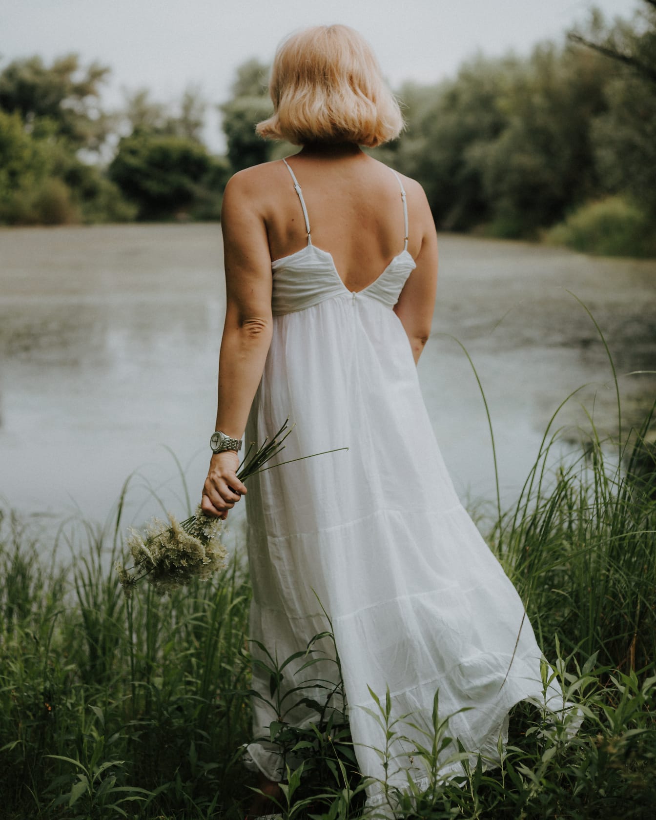 Классическое старомодное белое платье с открытой спиной на фотомодели блондинки