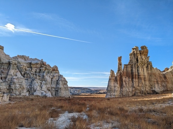 Formation rocheuse de grès à haute falaise dans une vallée désertique
