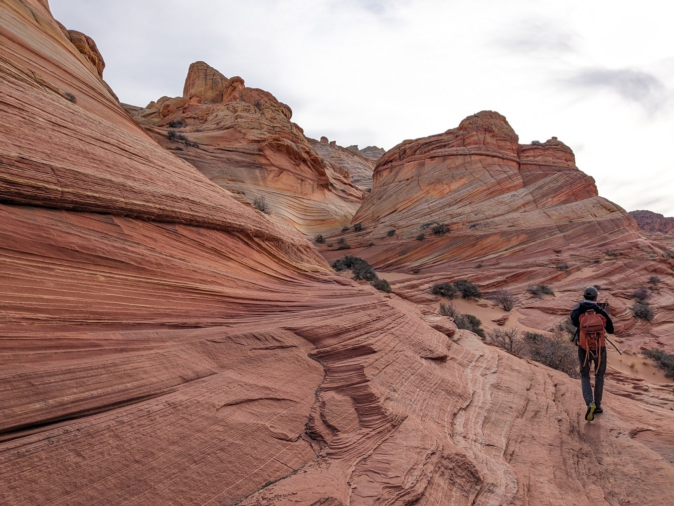 Excursionista mochilero caminando por un acantilado desértico en un parque natural