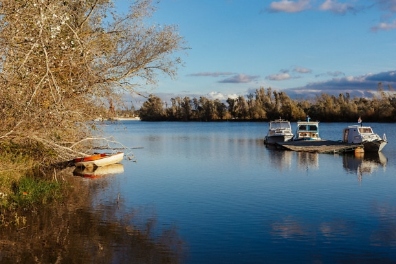 Calm atmosphere on lakeside shore with small fishing boats
