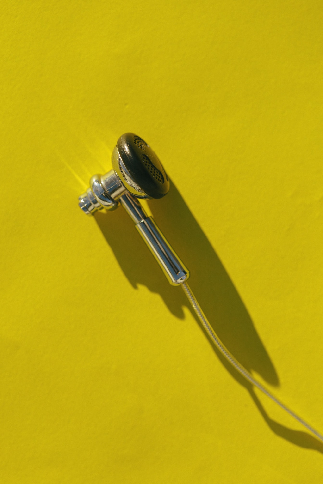 Маленькі навушники з нержавіючої сталі крупним планом на жовтому тлі