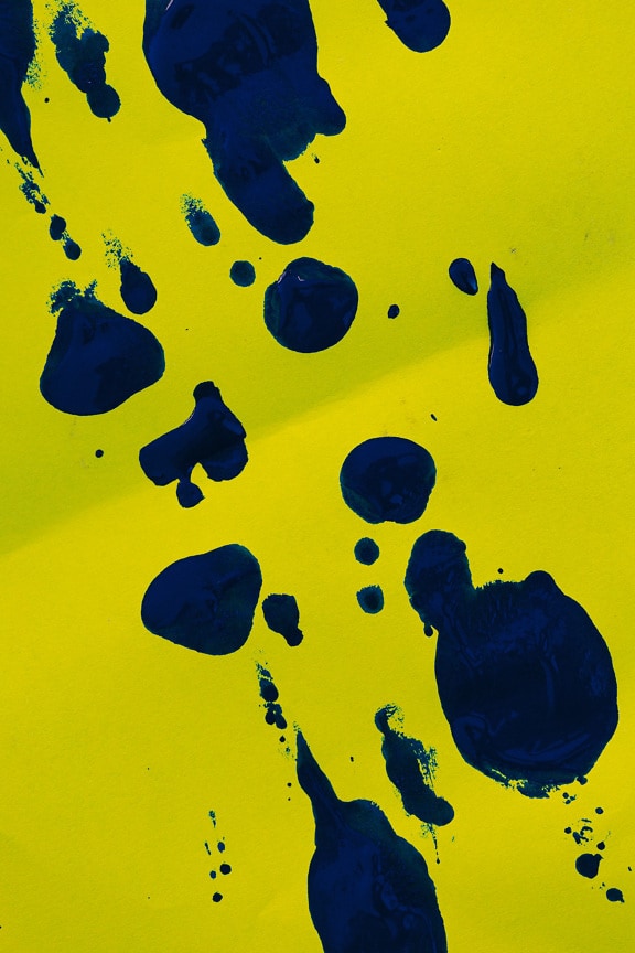 Dunkelblaue Aquarellfarbe auf leuchtend gelbem Papier Nahaufnahme