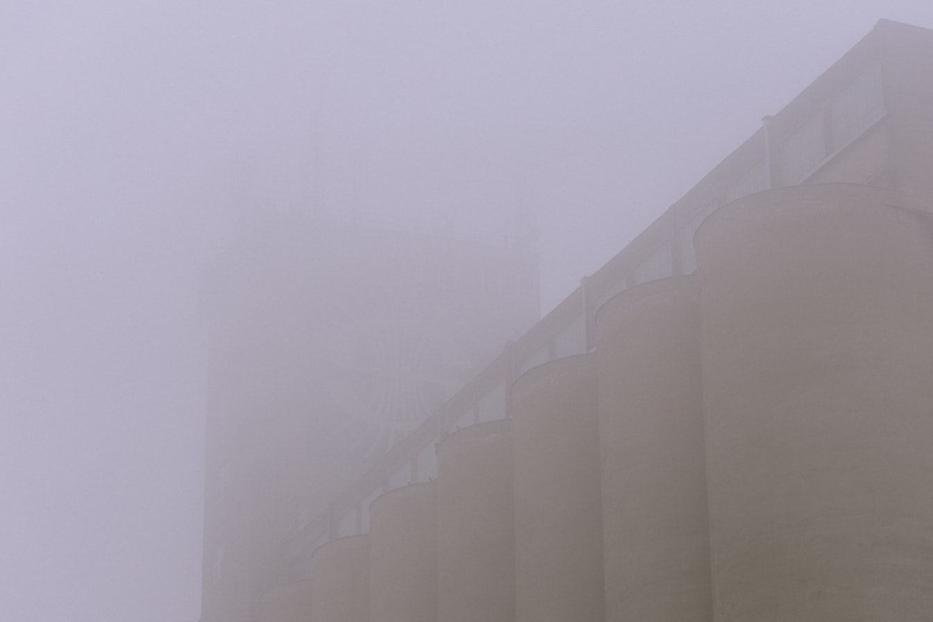 霧の中のコンクリートサイロの建物のシルエット