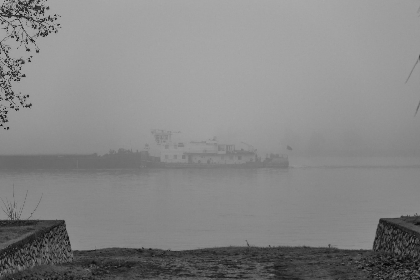Fotografia em preto e branco do navio de barcaça no nevoeiro no rio Danúbio