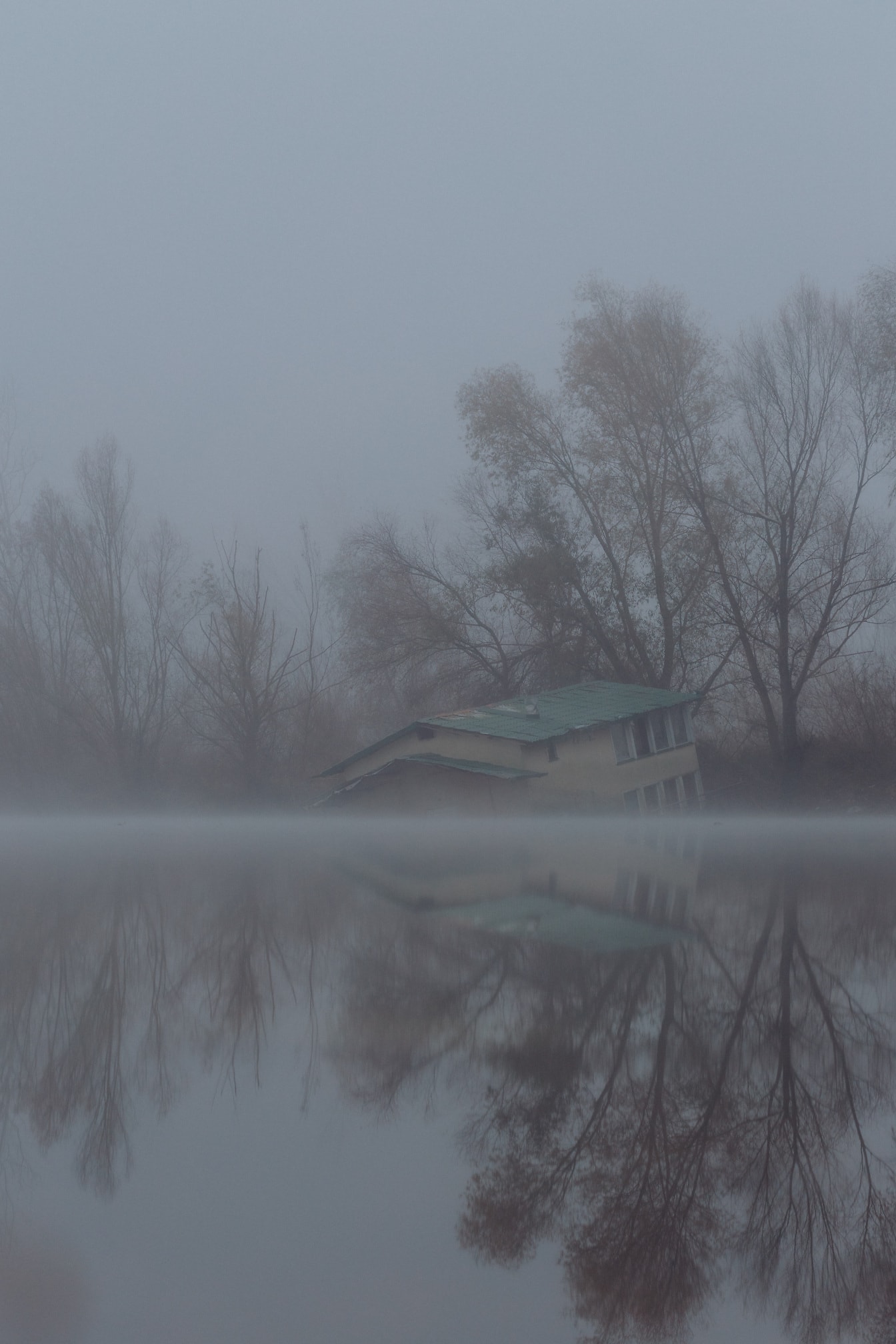 Oversvømmet bådhus på flodbredden af tåget søbred